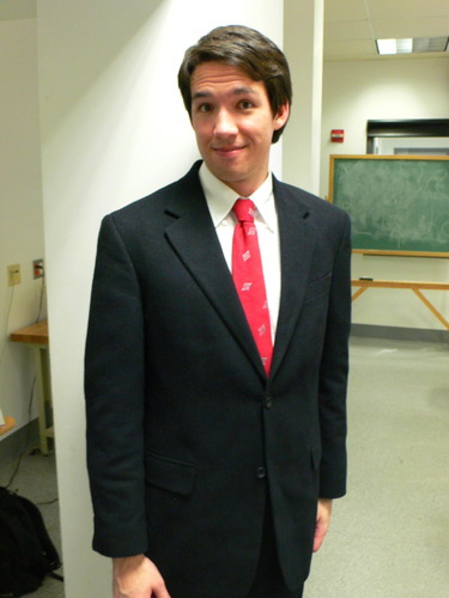 <p>the man wears a suit and a s red tie</p>