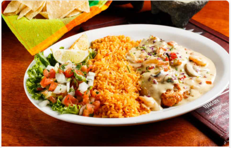 <p>Grilled tilapia fish smothered in our famous creamy wine sauce with sauteed shrimp and crawfish tails. Served with rice and your choice of beans.</p>