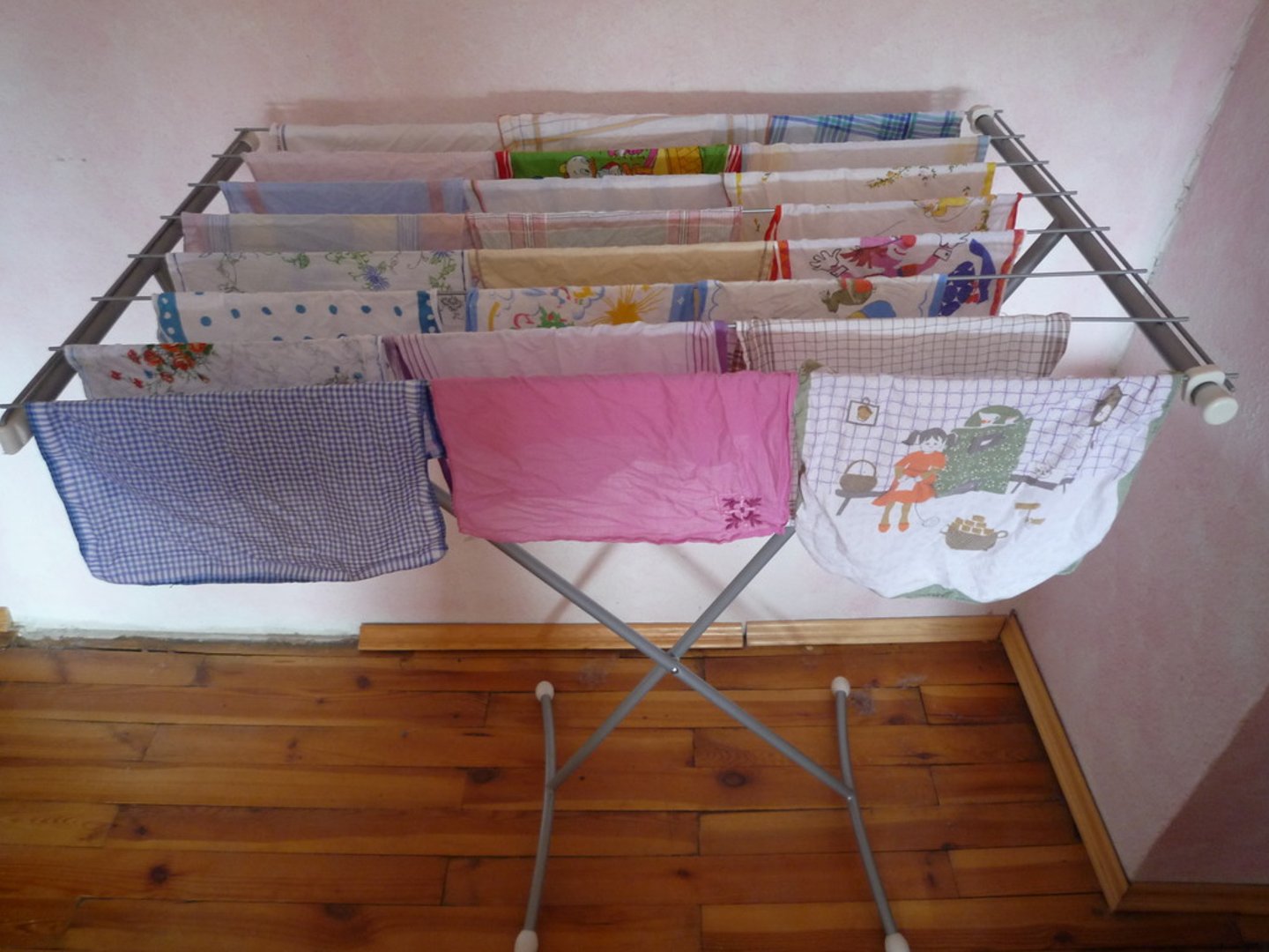 <p>A wooden or metal frame on which wet clothes can be hung to air and dry.</p><p>Example: Hang your shirts on the drying rack in the living room.</p>