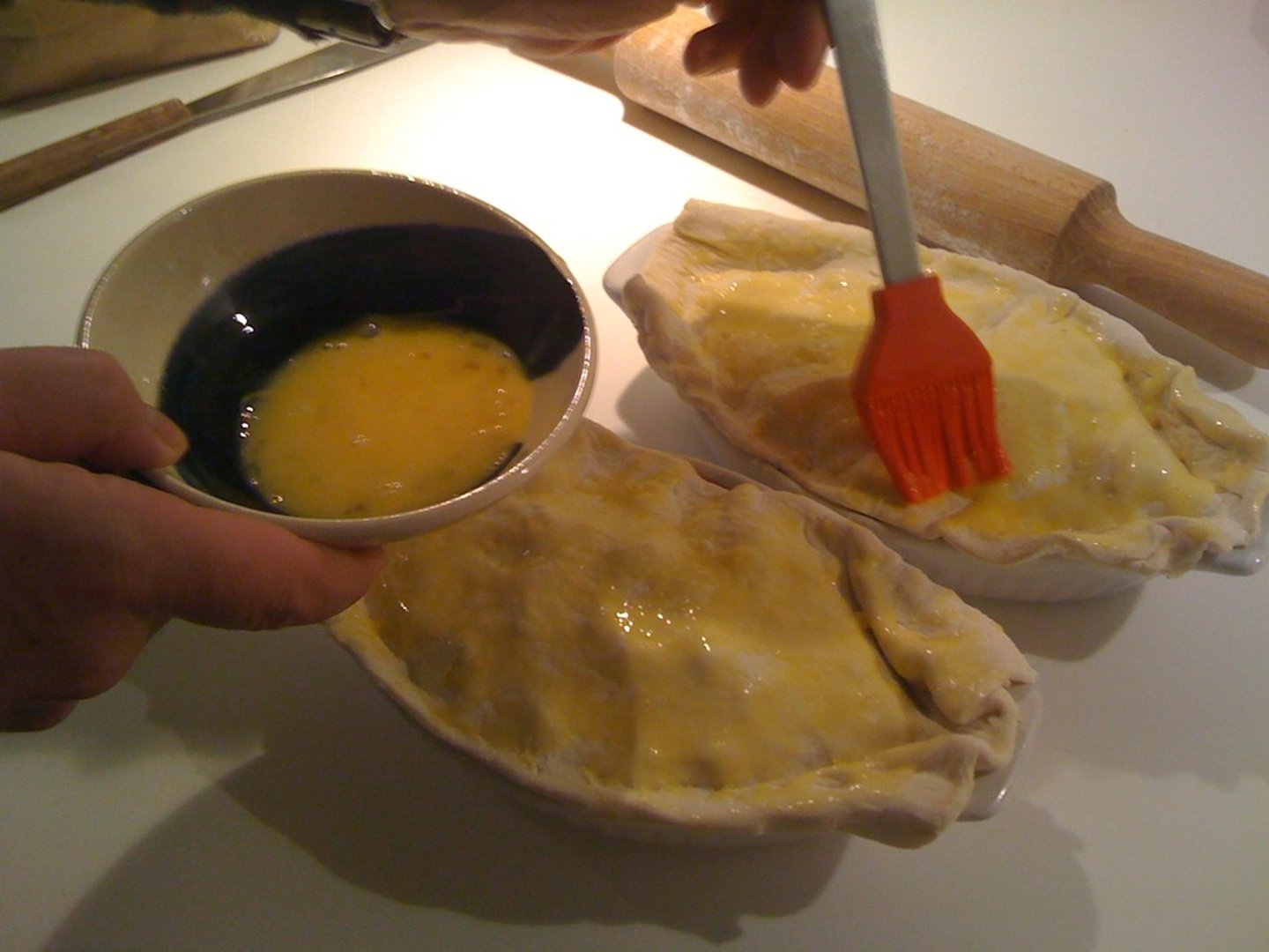 <p>using a pastry brush to coat food with a glaze or liquid</p>
