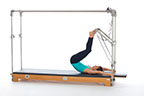 <p><strong>Setup</strong></p><ul><li><p>Lying supine, arms straight and overhead, hands holding poles (close to mat), legs straight and hip width apart, toes placed on PTBar and plantarflexed</p></li><li><p>Resistance: medium <strong>[bottom loaded] 1 or 2 springs + safety belt</strong></p></li></ul><p><strong>Movement</strong></p><ul><li><p>Exhale: Roll up onto shoulder girdle, simultaneously bend legs and extend hips</p></li><li><p>Inhale: Pause</p></li><li><p>Exhale: Roll down, simultaneously straighten legs</p></li><li><p>Inhale: Dorsiflex and plantarflex feet</p></li></ul><p><strong>Muscle Focus</strong></p><ul><li><p>Spinal flexors</p></li><li><p>Spinal extensors</p></li><li><p>Hip extensors</p></li></ul><p><strong>Objectives</strong></p><ul><li><p>Spinal articulation</p></li><li><p>Hip extensor control and stretch</p></li><li><p>Ankle-foot plantarflexor control and stretch</p></li></ul><p><strong>Cues</strong></p><ul><li><p>Keep arms straight and maintain scapular stabilization</p></li><li><p>Initiate movement with abdominals</p></li><li><p>Maintain hip extensor engagement when rolling up and down</p></li></ul><p></p>