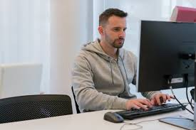 <p>The man is typing on a keyboard.</p>