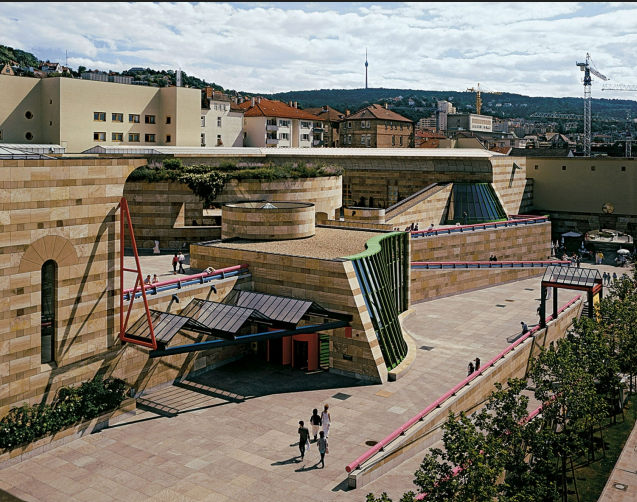 <p>Alongside the outside of the building there is a public pedestrian ramp that winds through and around the building, connecting street levels and integrating the museum into the urban topography of the hillside. Uses all kinds of mateirals such as classical travertine and sandstone, then modernist glass and steel, utilizing material eclecticism</p>