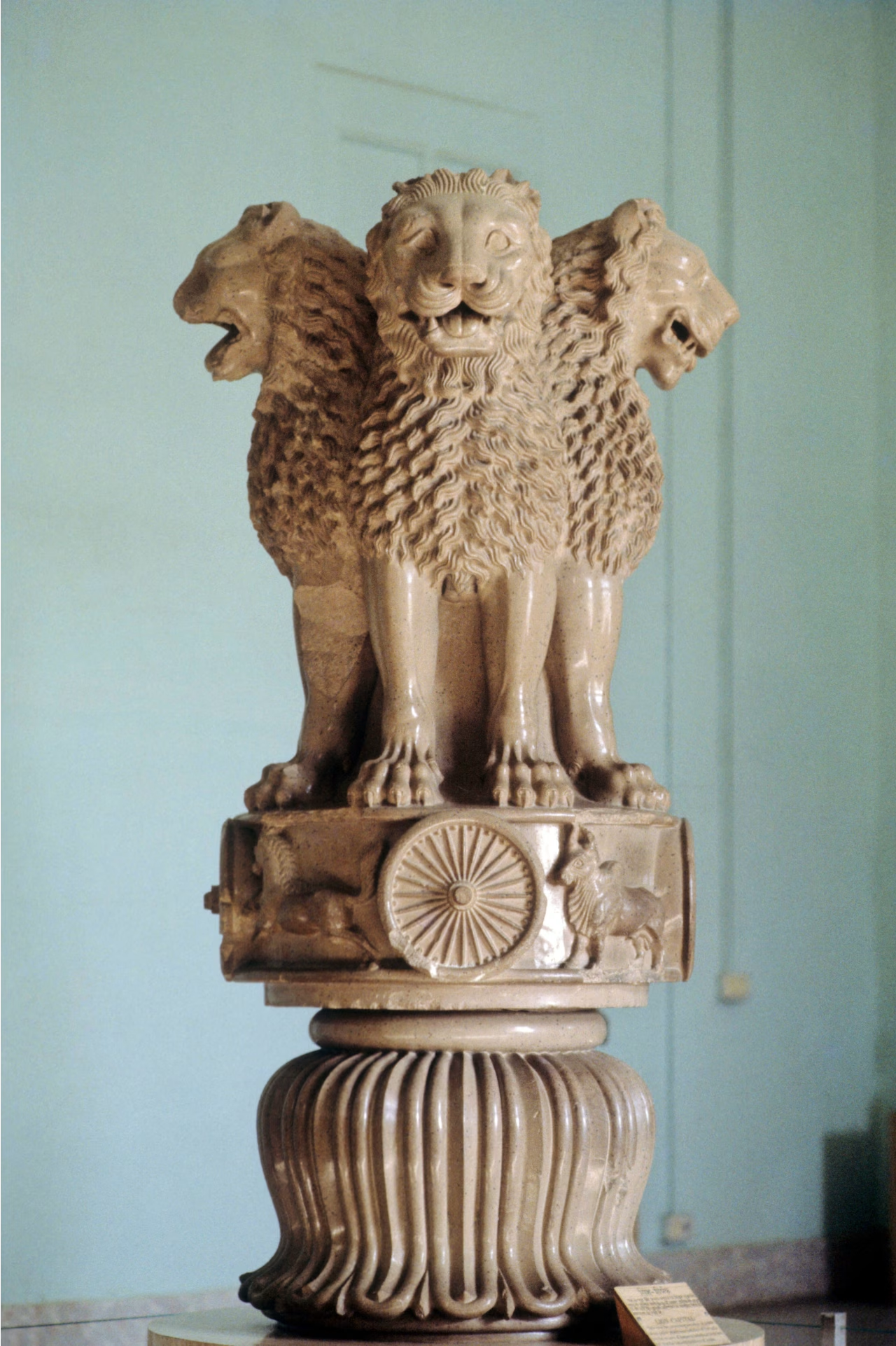 <p>Often with animal-shaped capitals, which is the Royal standard, for it symbolizes the axis mundi, joining the Earth with the cosmos. Marked the site of Buddha’s first sermon with 4 addorsed Asiatic lions for the cardinal directions. The base is an inverted lotus blossom leading to the platform of a bull, horse, lion, elephant, between chariot wheels symbolizing militaristic might and kingship. </p>