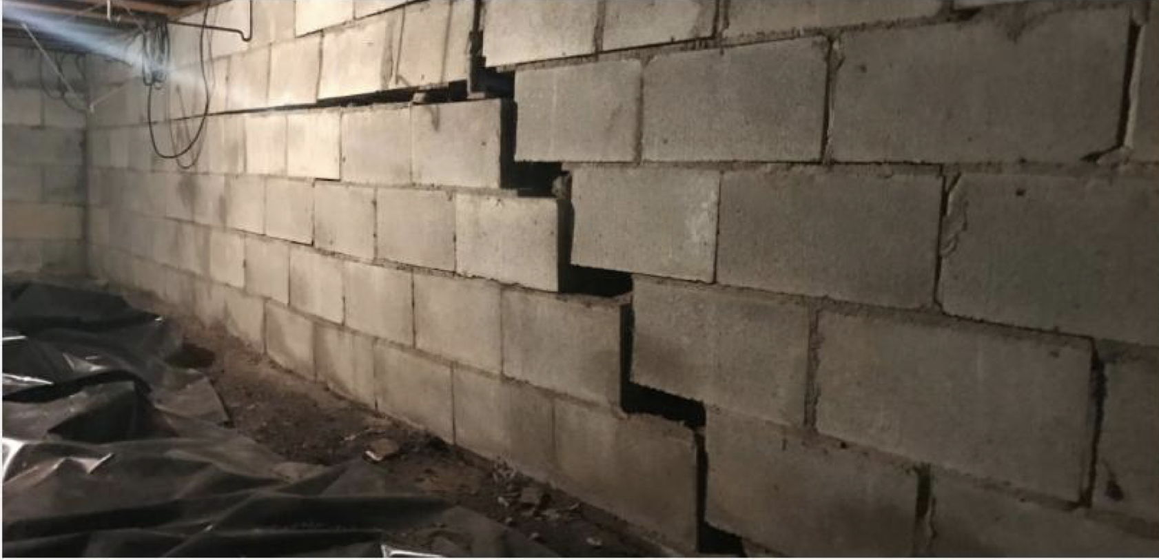 <p><strong>Hva kan du med faglig sikkerhet si om veggen på dette bildet?</strong></p><ol><li><p>Jordtrykket har vært høyere enn styrken i veggen</p></li><li><p>For lite isolasjon i veggen</p></li><li><p>Det har vært et jordskjelv</p></li><li><p>Noen har kjørt på veggen utenfra</p></li><li><p>For svake stendere</p></li><li><p>Det er brukt for dårlig mørtel</p></li><li><p>Det er for langt mellom stabiliserende bærevegger</p></li></ol><p></p>