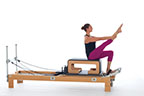 <p><strong>Setup</strong></p><ul><li><p>Sitting upright at front of Long Box, one foot under foot strap, other leg bent with thigh to chest, holding leg below knee, hands on shin</p></li><li><p>Resistance: <strong>all springs attached to hold carriage in place</strong></p></li></ul><p><strong>Movement</strong></p><ul><li><p>Exhale: Pump knee to chest 3 times</p></li><li><p>Inhale: Straighten leg, hinge back, holding above ankle</p></li><li><p>Exhale: Round back, walk hands down leg 3 times beginning with outside hand, lifting leg to perpendicular to floor</p></li><li><p>Inhale: Arch back over box, circle arms overhead and around, lift head and chest, rounding trunk , hold onto leg</p></li><li><p>Exhale: Walk hands up legs 3 times beginning with inside hand</p></li><li><p>Inhale: Straighten spine, bend leg, return to start position</p></li></ul><p><strong>Muscle Focus</strong></p><ul><li><p>Spinal flexors</p></li><li><p>Spinal extensors</p></li></ul><p><strong>Objectives</strong></p><ul><li><p>Spinal flexor control</p></li><li><p>Spinal extensor control</p></li><li><p>Hamstring stretch</p></li></ul><p><strong>Cues</strong></p><ul><li><p>Keep leg perpendicular to floor as arms circle around</p></li><li><p>Maintain pelvic lumbar stabilization as arms circle around</p></li></ul><p></p>