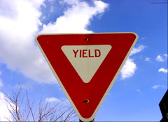 <p>A yield sign is triangular. It is red and white with</p><p>red letters. It means you must slow down and</p><p>yield the right-of-way to traffic in the intersection</p><p>you are crossing or roadway you are entering.</p>