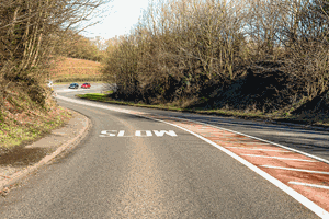 What's the reason for the hatched area along the centre of this road?