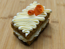 <p>Carrot cake made with coconut and crystallized ginger. Kept moist with pineapple and lemony cream cheese frosting</p>