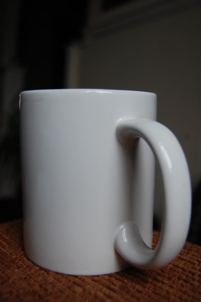 <p>A large cup with a handle, used for hot drinks like coffee, tea, or hot chocolate.</p><p>Example: She held a hot mug of cocoa to warm her hands.</p>