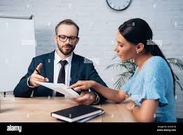 <p>The woman is pointing at a document.</p>