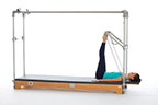 <p><strong>Setup</strong></p><ul><li><p>Lying supine, toes placed on PTBar, feet in small V position, legs bent</p></li><li><p>Resistance: medium to heavy <strong>[bottom loaded] 2 springs + safety belt</strong></p></li></ul><p><strong>Movement</strong></p><ul><li><p>Exhale: straighten legs</p></li><li><p>Inhale: bend legs, return to starting position</p></li></ul><p><strong>Muscle Focus</strong></p><ul><li><p>Hip extensors</p></li><li><p>Knee extensors</p></li></ul><p><strong>Objectives</strong></p><ul><li><p>Hip extensor strength</p></li><li><p>Knee extensor control</p></li><li><p>Foot alignment and stabilization</p></li><li><p>Hip adductor control</p></li><li><p>Pelvic lumbar stabilization</p></li></ul><p><strong>Cues</strong></p><ul><li><p>Establish plantarflexion when legs are straight</p></li><li><p>Keep heels stable, moving around ankle joint</p></li><li><p>Maintain hip extensor engagement</p></li><li><p>Maintain pelvic lumbar stabilization</p></li><li><p>Avoid excessive knee flexion (maximum 90 degrees)</p></li><li><p>Straighten legs completely, avoiding hyperextension</p></li></ul><p></p>