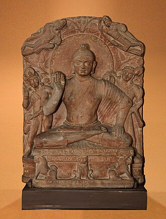 <p>There is 2 attendants behind the main Buddha figure, as there is a halo of radiating light (scallops) behind him, with the pipal tree and top knot symbolizing enlightenment. There are also celestial beings that are above, as the main figure has chakra wheel impressions on his hands and feet. </p>