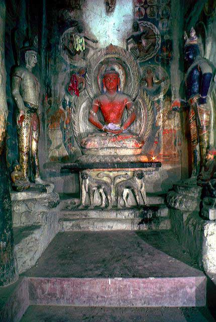 <ul><li><p><span style="background-color: transparent;">one of the two main images of the temple</span></p></li><li><p><span style="background-color: transparent;">flanked by two standing Bodhisattvas</span></p><ul><li><p><span style="background-color: transparent;">difficult to securely identify the bodhisattvas in the Cella because they have been repainted many times, based on their arm positions + traces of color possibly represent Avalokitesvara and Vajrasattva</span></p></li></ul></li><li><p><span style="background-color: transparent;">being offered flowers by four deities</span></p></li><li><p><span style="background-color: transparent;">generally interpreted as Buddha Amitabha (red body color, meditation gesture), but was originally an ancient form of Vairocana (lion throne, holds wheel in meditation gesture</span></p></li></ul><p></p>